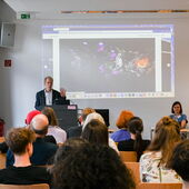 Matthias Schwartz stands at the lectern and speaks to the audience.