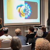 Aleksandra Ćwiek steht vor einer Leinwand und spricht zum Publikum.