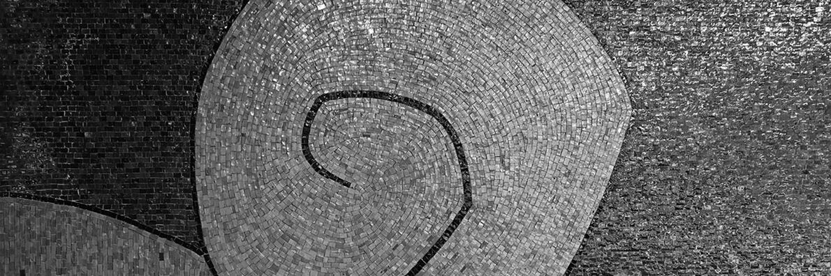 A snail-shaped mosaic made of small, shiny stones.