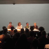 The four authors sit on a podium. Christine Kutschbach looks to the audience.