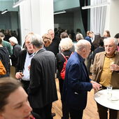 Mehrere Dutzend Personen stehen in lockeren Grüppchen beeinander, es gibt Sekt.