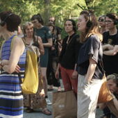 Several people listen to Cord Riechelmann's guided tour using headsets. Hanna Hamel stands in the front on the right.