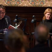 Bov Bjerg und Christine Kutschbach sitzen am Lesetisch, Bov Bjerg liest aus einem Buch