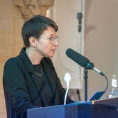 Julija Cimafiejeva performs at the lectern.