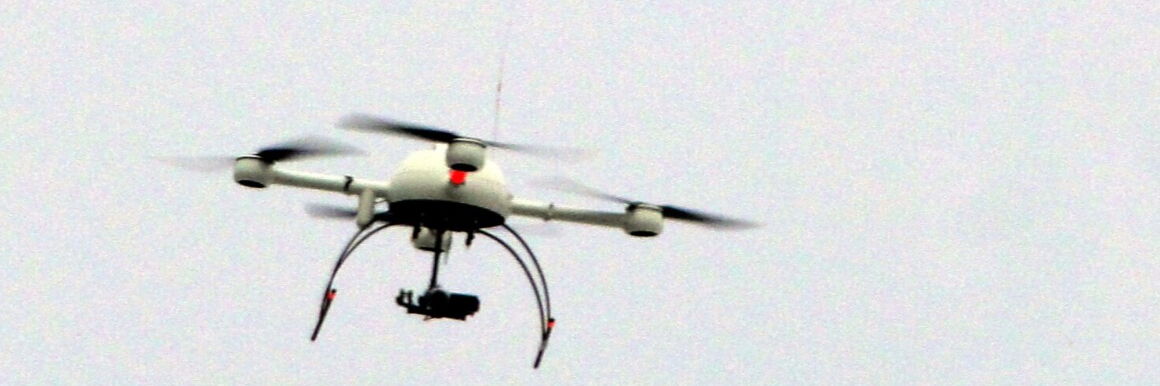 Close up photo of a police drone flying in the sky with a camera attached.