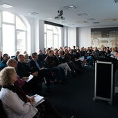 Das gut besuchte Publikum der Tagung, vorne am Pult spricht ein Redner