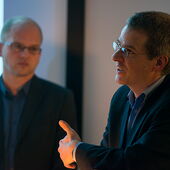 Close-up von Daniel Weidner beim Vortragen. Neben ihm steht Stefan Willer.