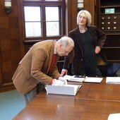 Ernst Müller mit einem Workshopteilnehmer an einem Holztisch.