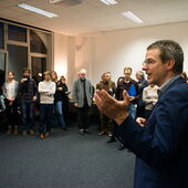 Daniel Weidner spricht vor einem im Kreis stehenden Publikum