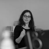 Black and white photograph of Tatjana Petzer, she speaks and gestures.