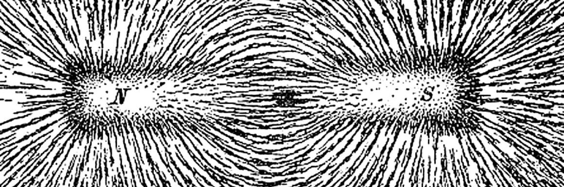 A bar magnet with iron filings on a sheet of paper aligned along the magnetic field lines, visually revealing the magnet’s magnetic field.