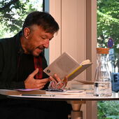 Lukas Bärfuss liest angeregt aus einem Buch vor.