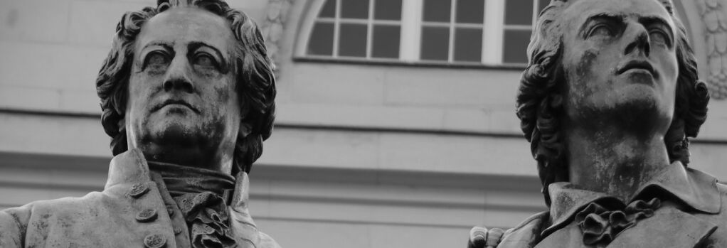 Schwarzweißaufnahme des Goethe-Schiller-Denkmals in Weimar, im Ausschnitt sind die Köpfe der beiden Dichter zu sehen.