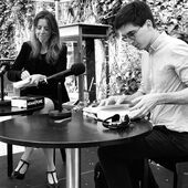 Janika Gelinek und Juan S. Guse sitzen auf einer kleinen Bühne und haben Bücher in den Händen.