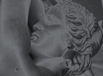 Black and white photograph of a Greek statue, detail: profile of a figure with wavy hair and left arm stretched upwards.